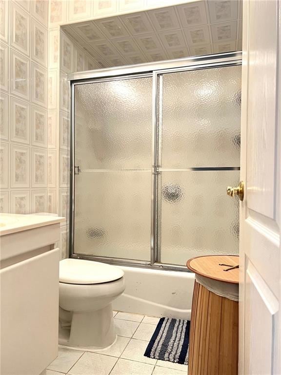 full bathroom with enclosed tub / shower combo, vanity, tile patterned floors, and toilet