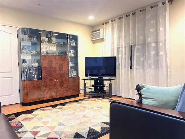 living room with hardwood / wood-style floors, a wall unit AC, and baseboard heating