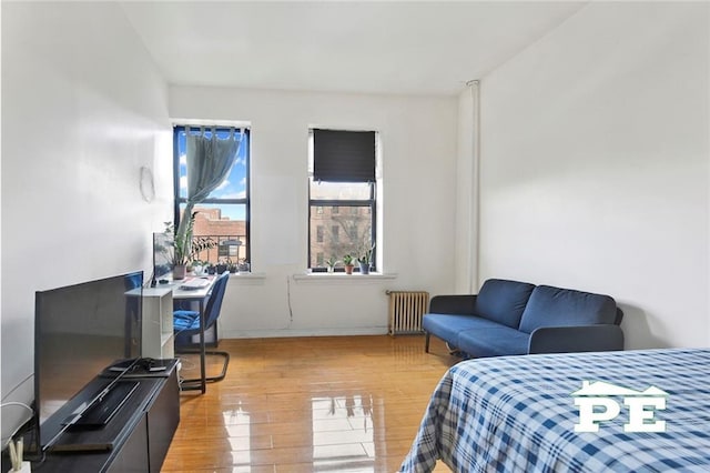 bedroom with radiator and light hardwood / wood-style flooring