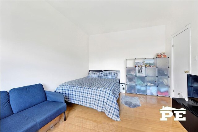 bedroom featuring wood-type flooring and vaulted ceiling