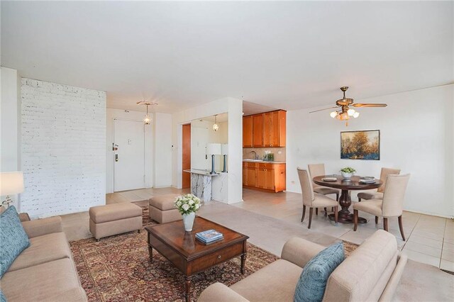 tiled living room featuring ceiling fan and sink