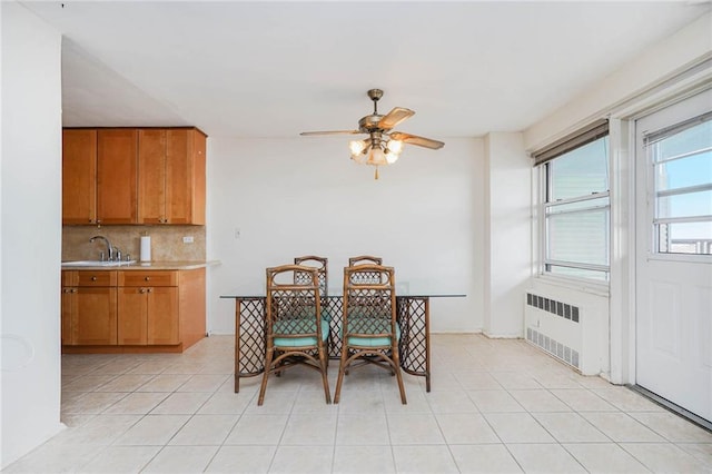 dining area featuring a ceiling fan, light tile patterned flooring, and radiator heating unit