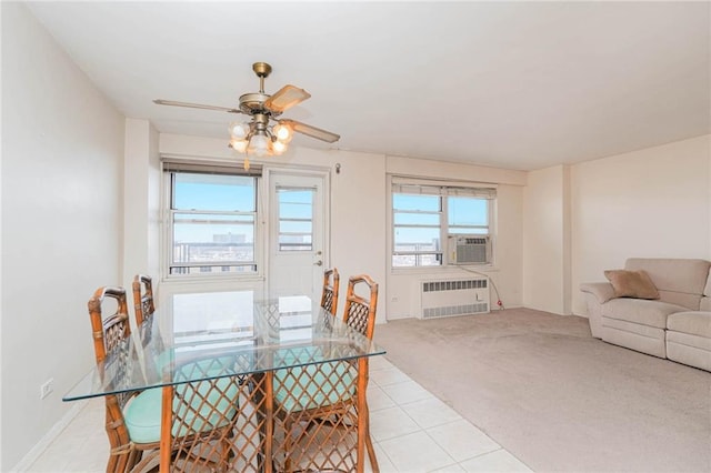 dining room featuring a ceiling fan, radiator heating unit, cooling unit, light tile patterned floors, and light colored carpet