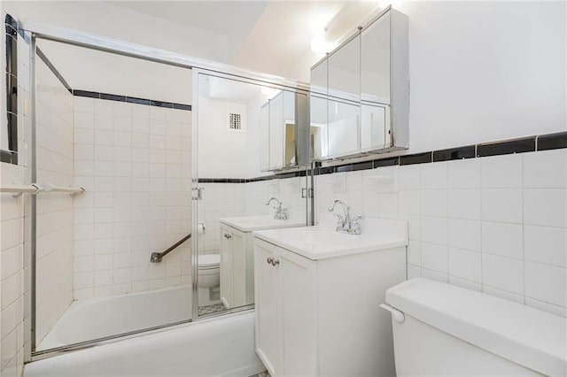 full bath featuring tile walls, toilet, visible vents, and combined bath / shower with glass door