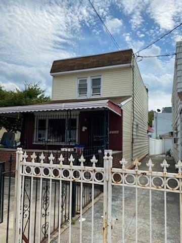 view of front of home featuring a porch, a fenced front yard, and a gate