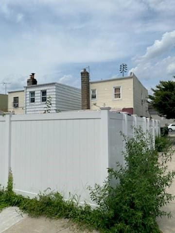 view of side of property with a chimney and fence