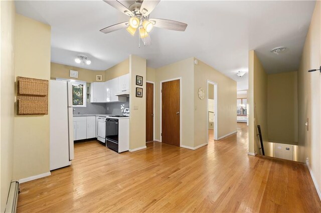 kitchen with light wood-type flooring, white appliances, baseboard heating, ceiling fan, and white cabinets