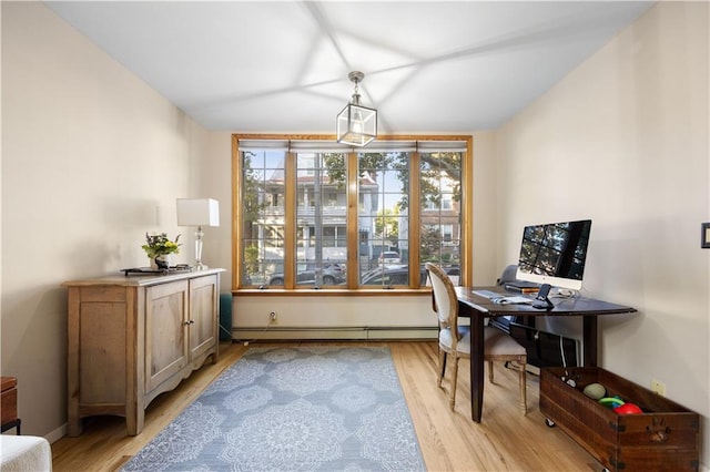 home office with light hardwood / wood-style flooring and a baseboard heating unit