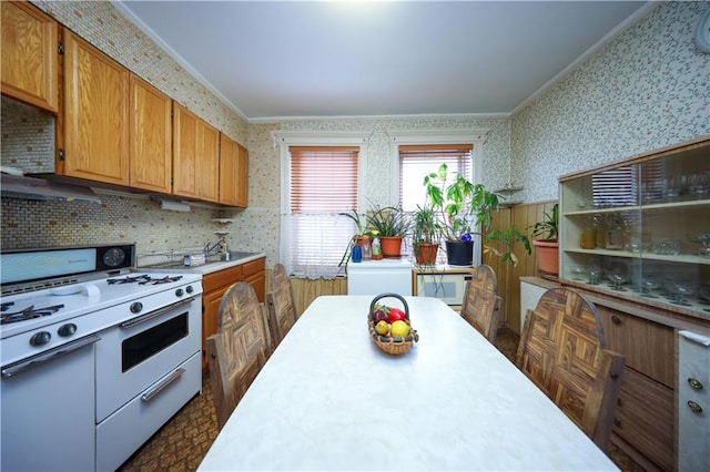 kitchen featuring ornamental molding, backsplash, and white gas range oven