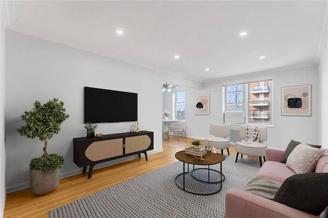 living room with ornamental molding and light hardwood / wood-style floors