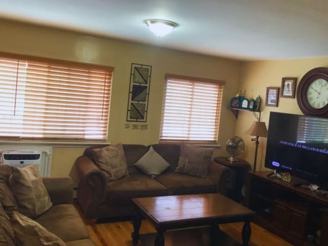 living room featuring hardwood / wood-style flooring and an AC wall unit