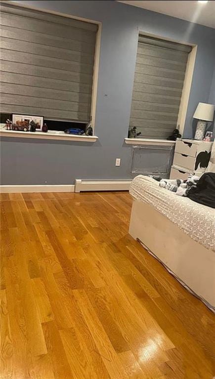 unfurnished bedroom featuring light hardwood / wood-style flooring and baseboard heating