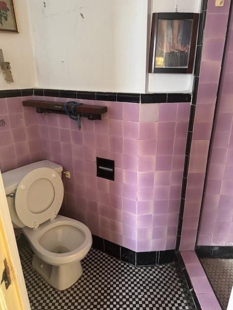 bathroom with tile walls and toilet