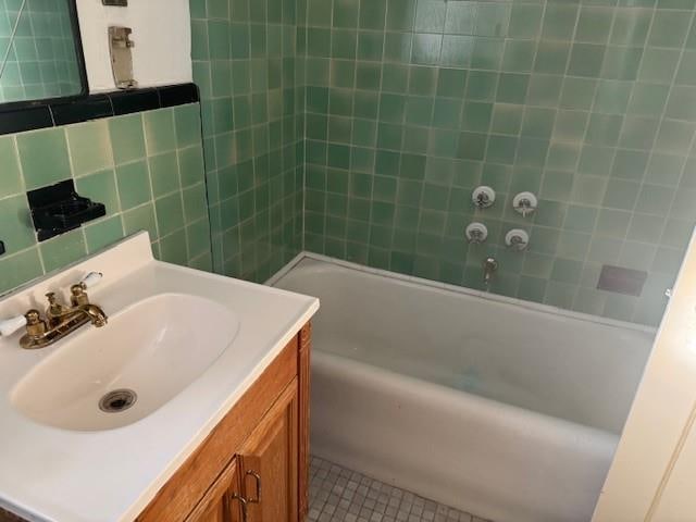 bathroom featuring tile patterned floors, vanity, tile walls, and backsplash