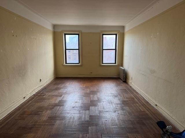 empty room with radiator and dark parquet floors