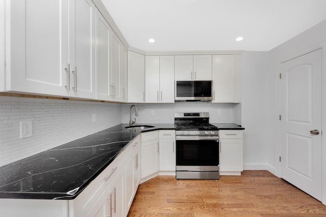 kitchen with white cabinetry, sink, decorative backsplash, light hardwood / wood-style floors, and stainless steel appliances