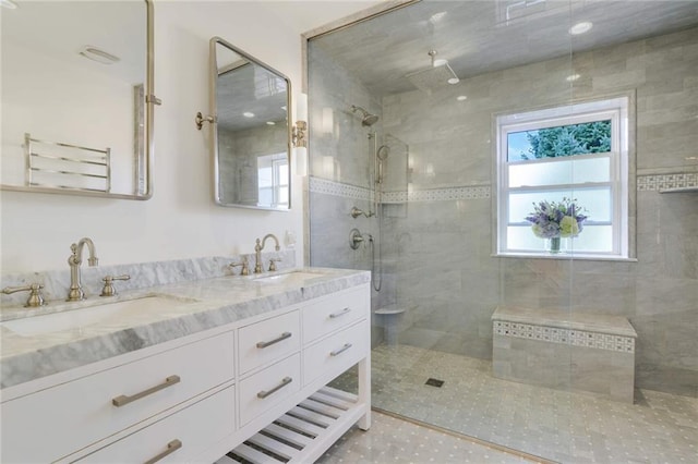 full bathroom featuring a sink, walk in shower, double vanity, and tile patterned flooring