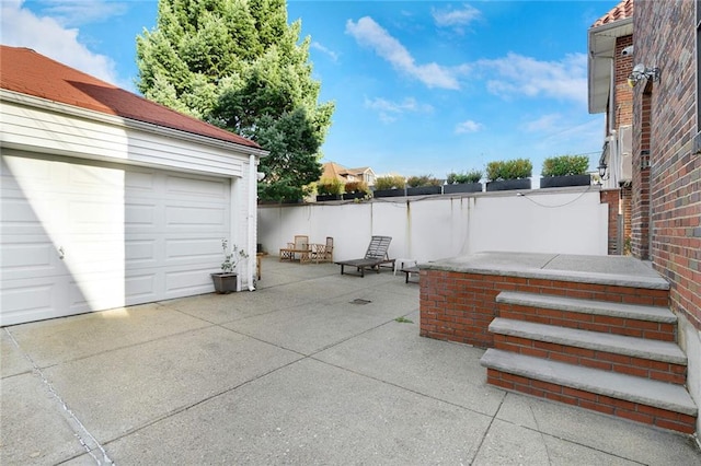 exterior space featuring a garage, concrete driveway, and fence