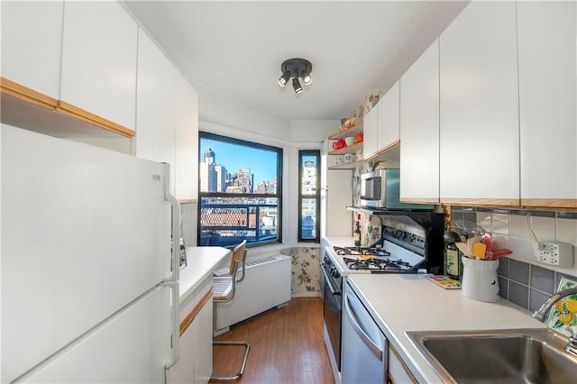 kitchen with dark hardwood / wood-style flooring, white cabinetry, sink, and stainless steel appliances