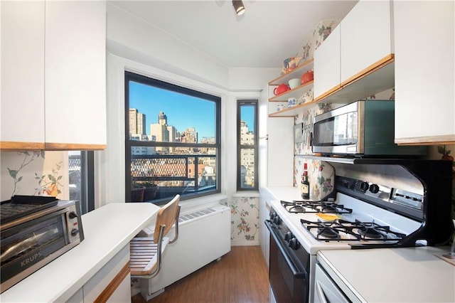 kitchen featuring dark hardwood / wood-style flooring, white cabinets, and appliances with stainless steel finishes