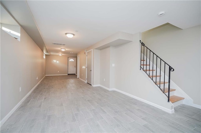 basement with visible vents, light wood-type flooring, stairs, and baseboards