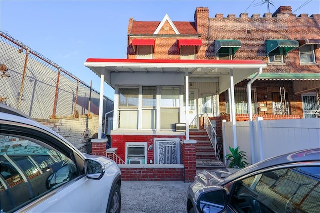 view of front facade with brick siding and fence