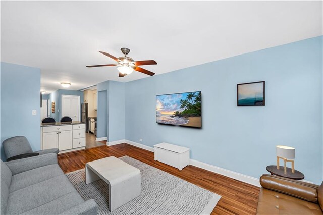 living room featuring ceiling fan and hardwood / wood-style floors