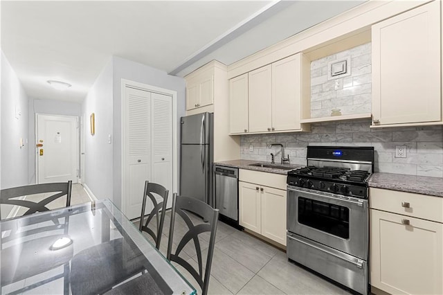 kitchen featuring sink, light tile patterned floors, stainless steel appliances, and backsplash