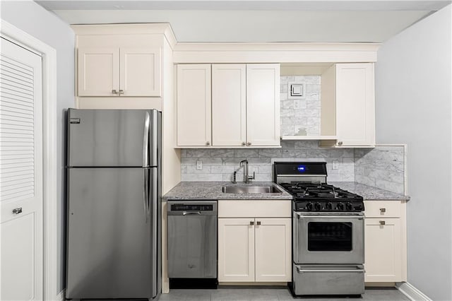 kitchen featuring tasteful backsplash, appliances with stainless steel finishes, sink, and white cabinets