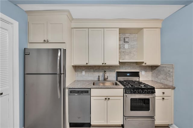 kitchen with sink, backsplash, and appliances with stainless steel finishes