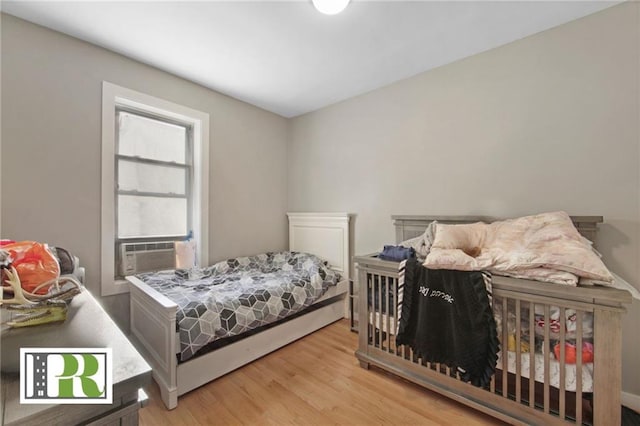 bedroom featuring cooling unit and wood finished floors