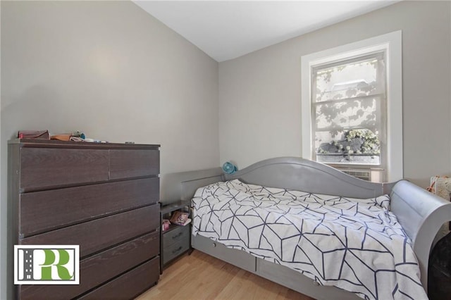 bedroom with vaulted ceiling and light wood finished floors