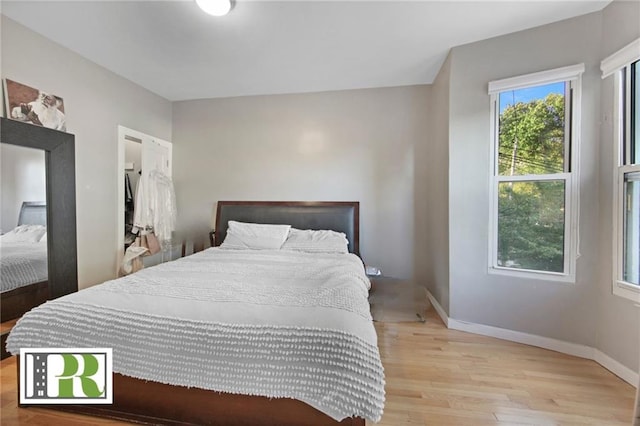 bedroom with light wood-style flooring and baseboards