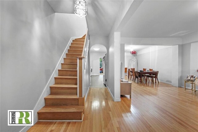 stairs with a chandelier and wood-type flooring