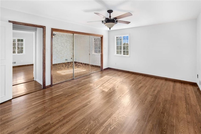 unfurnished bedroom with hardwood / wood-style flooring, ceiling fan, and a closet