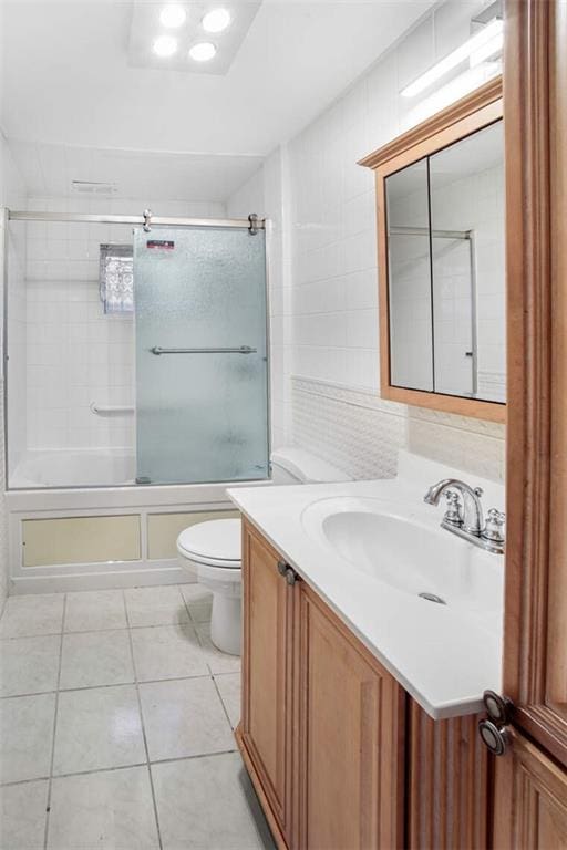 full bathroom featuring toilet, tile patterned floors, bath / shower combo with glass door, and vanity