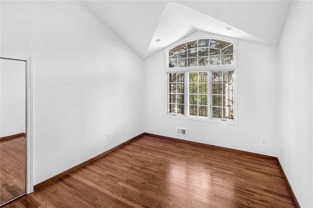 unfurnished room with lofted ceiling and wood-type flooring