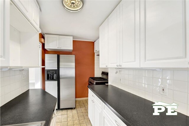 kitchen featuring white cabinetry, stainless steel appliances, decorative backsplash, and light tile patterned floors