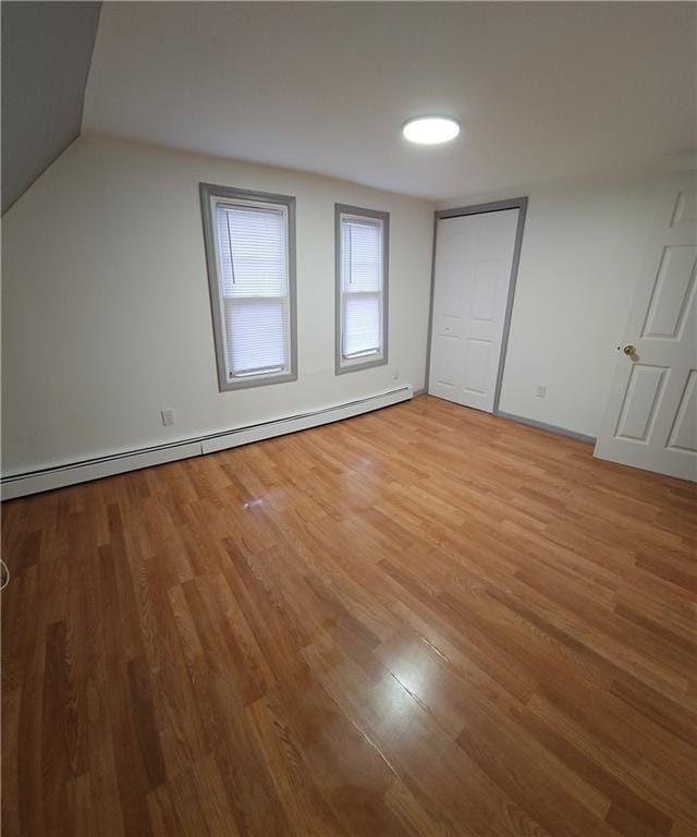 bonus room featuring wood-type flooring and a baseboard radiator