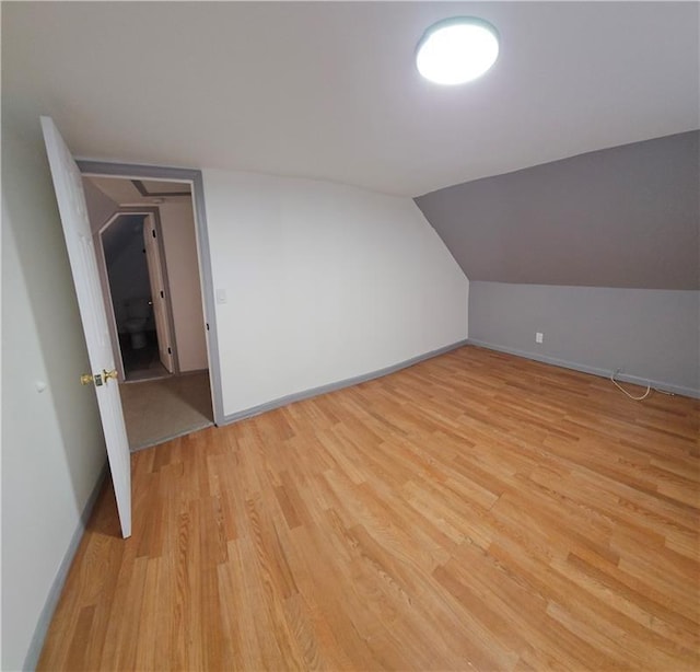 bonus room with lofted ceiling and light hardwood / wood-style floors