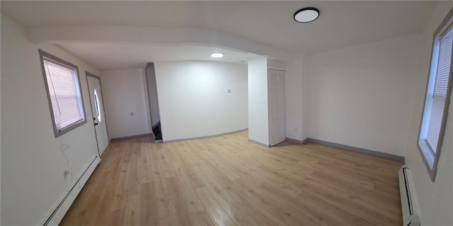 empty room featuring baseboard heating and light wood-type flooring