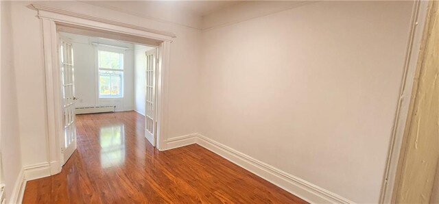 hallway with baseboard heating and hardwood / wood-style floors