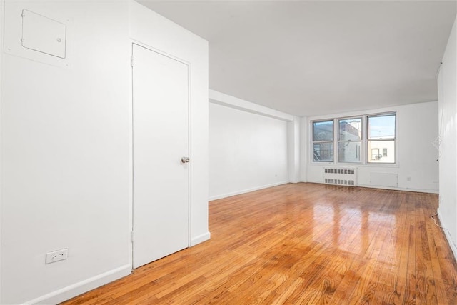 2035 E 7th St Unit 5F, Brooklyn, NY 11223 - spare room featuring radiator heating unit and light wood-type flooring