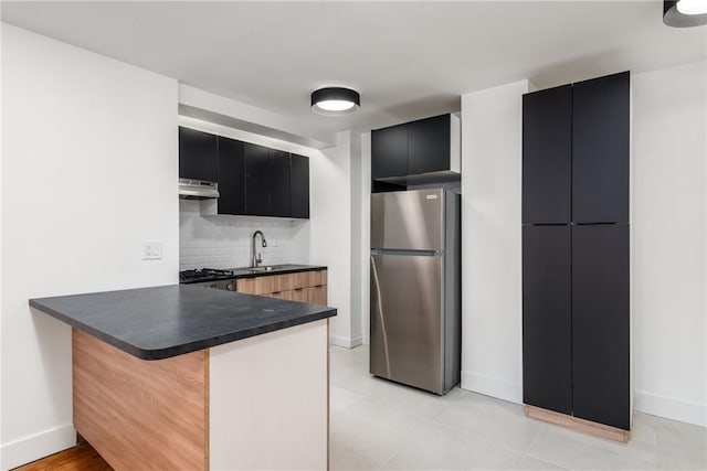 2035 E 7th St Unit 3E, Brooklyn, NY 11223 - kitchen featuring freestanding refrigerator, dark cabinetry, dark countertops, modern cabinets, and under cabinet range hood