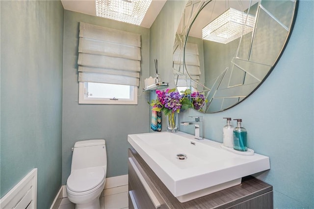 bathroom with toilet, tile patterned flooring, baseboards, and vanity