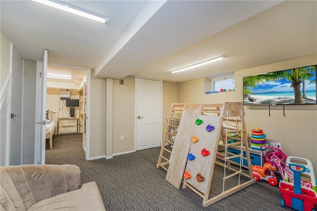 recreation room featuring dark colored carpet and baseboards