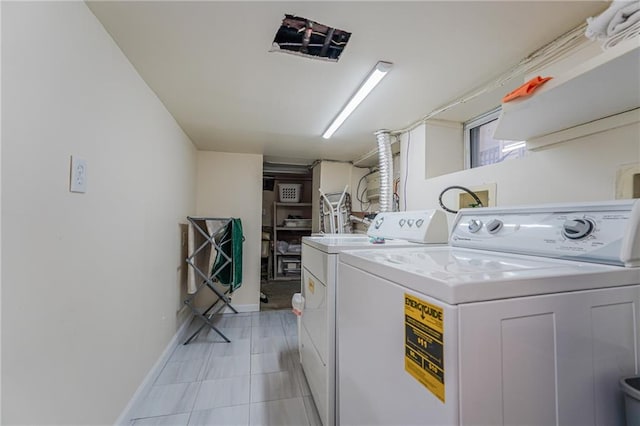 clothes washing area featuring laundry area, independent washer and dryer, and baseboards