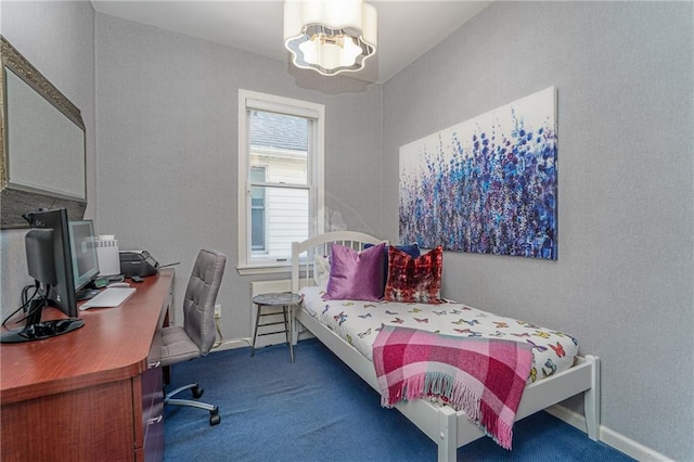 bedroom with dark colored carpet, baseboards, and an inviting chandelier