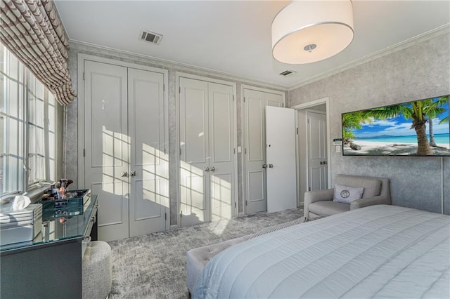 carpeted bedroom featuring visible vents and ornamental molding