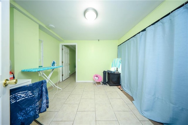 interior space with baseboards and light tile patterned floors